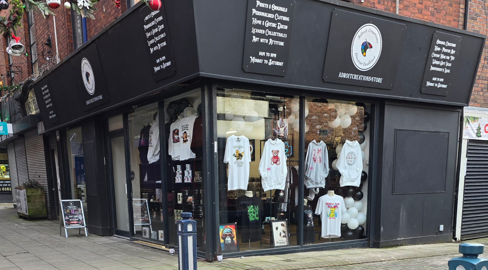 Storefront with our clothing displayed in the windows, featuring our brand logo on the door.